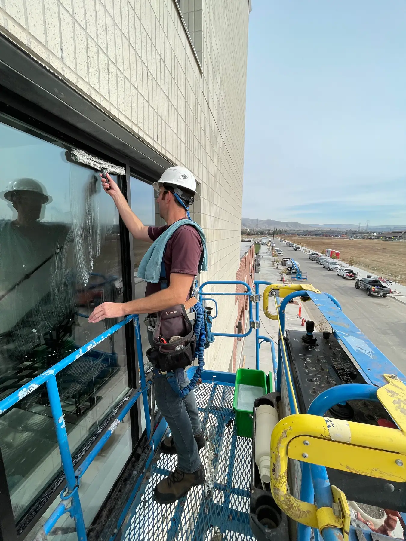 High-rise exterior window scrubbing from a lift