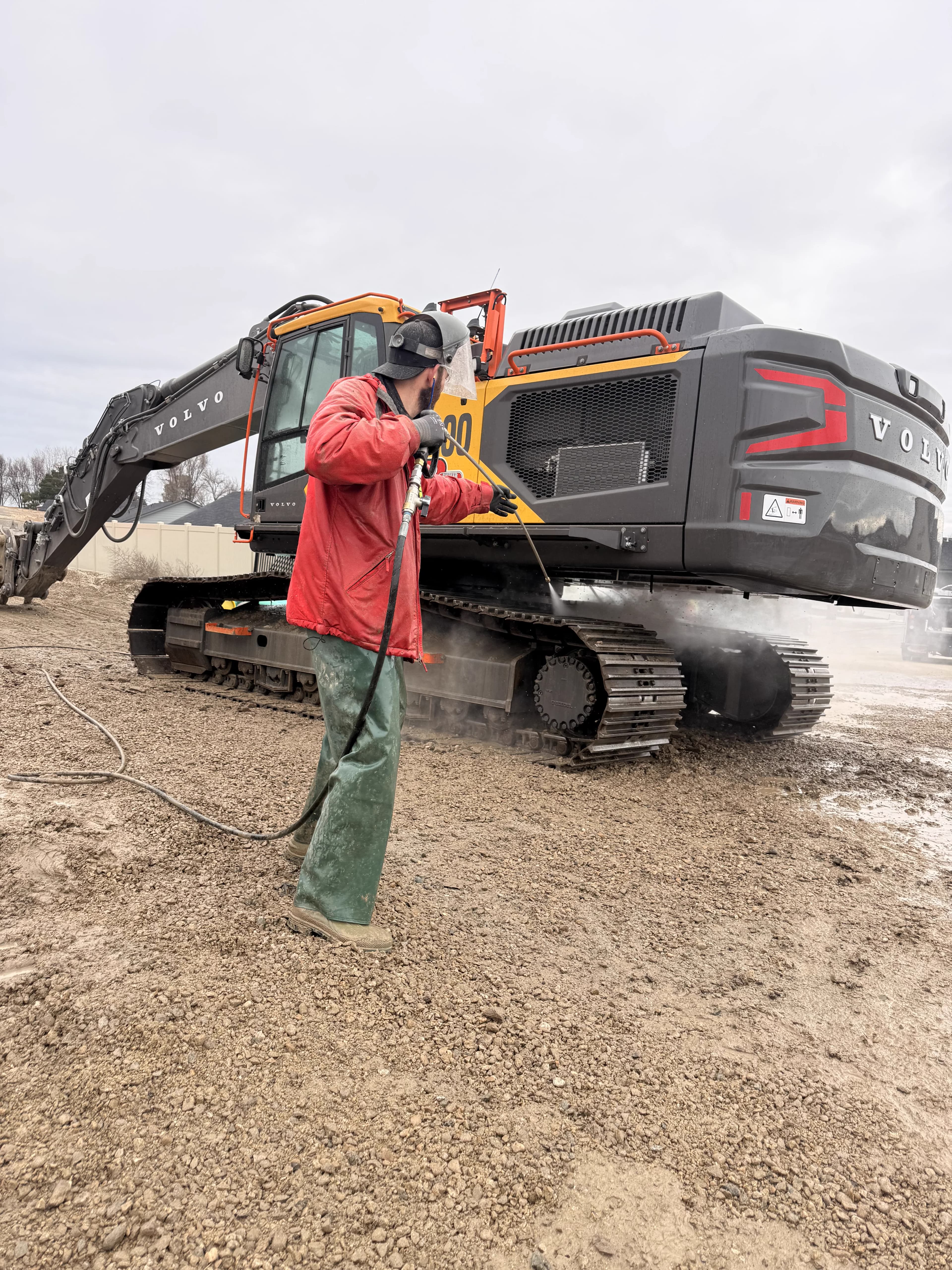 Heavy equipment power washing on a Volvo excavator in Boise